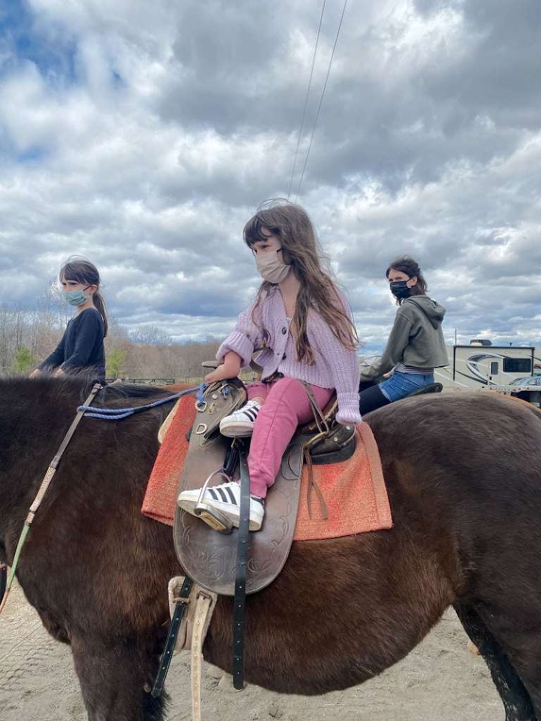 A photo of Zuzu, Lamp and PSP on horses with lots of clouds in the background. 